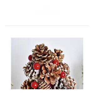Detail of pine cones and red berries with artificial snow on burlap base