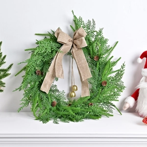 Nordischer grüner Weihnachtskranz mit Kiefernzapfen, goldenen Glocken und Sackleinenbogen