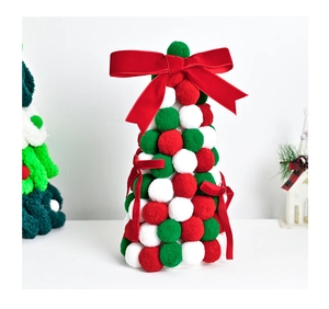 Macro detail of Christmas tree ornament with red and green pom-poms and velvet bow