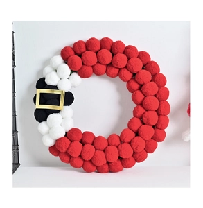 Detail of Santa Claus wreath with red, white and black plush pompom balls and gold belt buckle