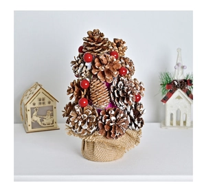 Detail of pine cone Christmas tree with red berries and a rustic burlap base