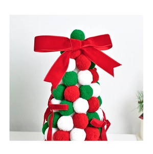 Detail of red and green plush pom-pom Christmas tree with velvet bow on top