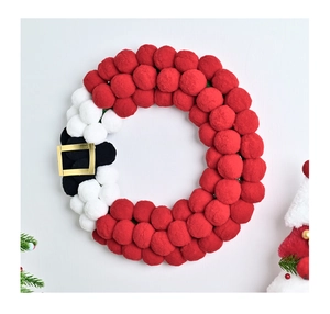 Detail of Santa Claus-themed Christmas wreath with red and white pom-poms and golden buckle