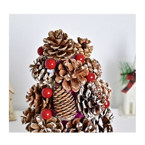Close-up of snowy pine cones and red berries on a rustic mini Christmas tree ornament