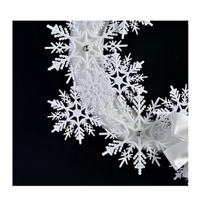 Dettaglio macro di ghirlanda di fiocchi di neve bianchi con strass e fiocco di raso