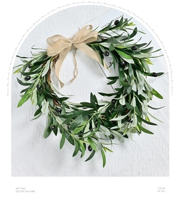 Close-up of olive leaf wreath with dark berries and a rustic burlap ribbon bow