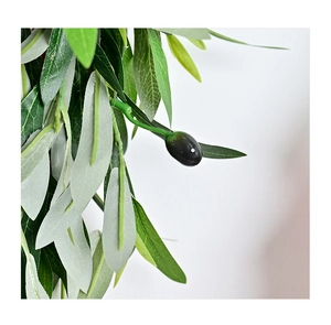 Close-up of lifelike artificial olive branch with green leaves and a dark purple fruit