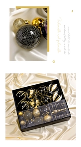 Dettaglio di palline di Natale nere e oro con texture glitter e opache in scatola regalo
