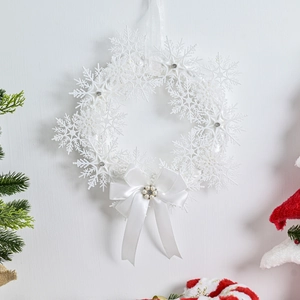 Ghirlanda di fiocchi di neve bianchi con fiocco di raso per decorazioni natalizie