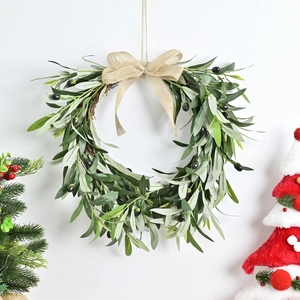 Christmas olive leaf wreath with burlap bow and purple berries on a white wall decor