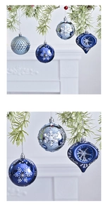 Close-up of blue and silver Christmas ornaments with snowflake patterns on pine branch