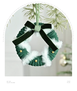 Macro view of green knitted Christmas wreath with gold beads and a velvet bow decoration