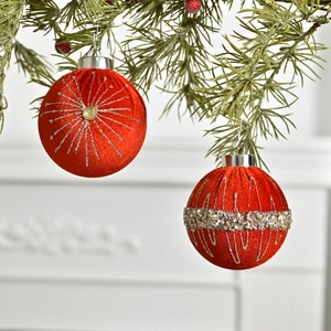 Luxurious red velvet Christmas ball ornaments with silver glitter and sequins on a pine branch