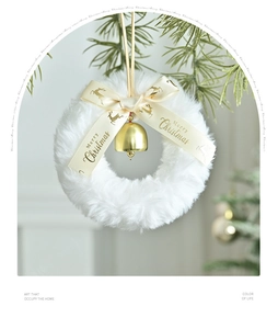 Détail d'une couronne de Noël en peluche blanche avec cloches dorées et ruban de renne