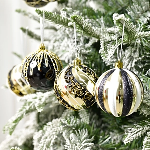 Lussuose palline di Natale nere e oro appese a un albero di Natale innevato