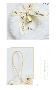 Détail d'une couronne de Noël en fausse fourrure blanche avec nœud de renne doré et cloche