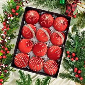 Close-up of 12 red velvet Christmas balls with glitter patterns in a gift box packaging