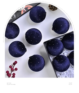 Flat lay of navy blue velvet Christmas ball ornaments with starry dots in a gift box