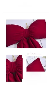 Detail of large red velvet Christmas bow featuring plush texture and gold wire tie