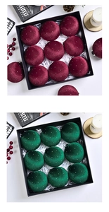Detail of burgundy and emerald velvet Christmas ball ornaments with white dots in a gift box