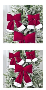 Detail of red velvet Christmas bows with white faux fur trim hanging on snowy tree branches