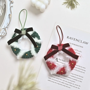Miniature red and green knitted Christmas wreaths with velvet bows and golden bell accents