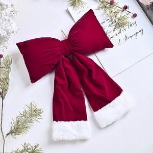 Red velvet Christmas tree bow topper with plush white edges and pine cone decor