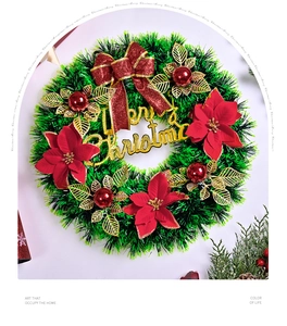 Close-up of a Christmas wreath with red bow, golden Merry Christmas sign and poinsettia