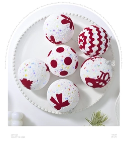 Detailed view of 6-piece white foam Christmas balls with red velvet patterns on a tray