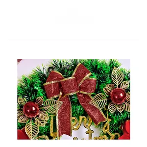 Close-up of a Christmas wreath with a red glitter bow and golden Merry Christmas sign