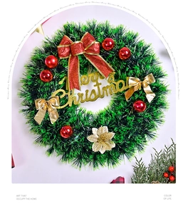 Detail of Christmas wreath with red bow, golden Merry Christmas sign and glittery flower