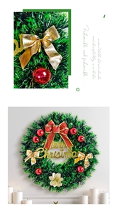 Detail of Christmas wreath with gold Merry Christmas sign and red ribbon bow ornaments