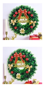 Detail of Christmas wreath with red bows, gold ornaments and Merry Christmas sign