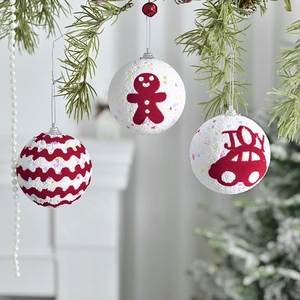 Christmas foam balls with gingerbread man and JOY car designs on a festive pine tree