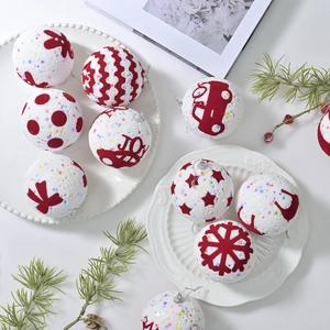 Christmas foam balls with glitter and red flocked JOY patterns on white background