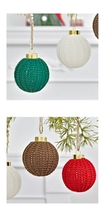 Macro view of handmade crochet Christmas balls with knit texture on pine branches