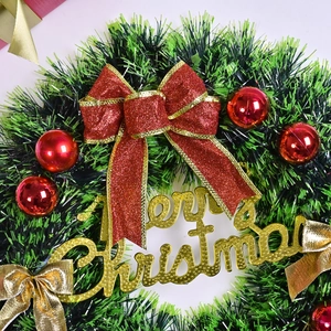 Lush Christmas wreath with pine needles, red bow, ornaments and Merry Christmas sign