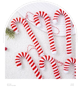 Close-up of red and white striped knit candy cane ornaments with festive pine and berry accents