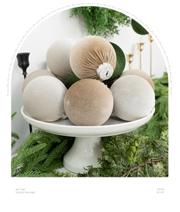 Close-up of elegant flocked velvet Christmas balls in assorted earth tones on a white tray
