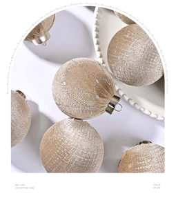 Close-up of champagne gold velvet Christmas balls with glitter texture in a white bowl