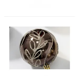 Close-up of 8cm bronze Christmas ball with gold glitter leaf patterns and shiny finish