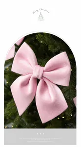Macro shot of a premium pink velvet Christmas bow ornament hanging on a festive pine tree
