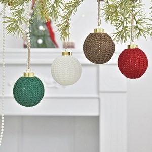 Handmade crochet Christmas ornaments set hanging on pine branches with twine loops
