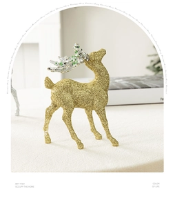 Detailed close-up of a glittering gold Christmas reindeer ornament with green antler accents