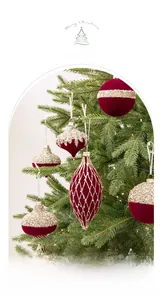 Gros plan d'ornements de Noël floqués rouges avec motifs pailletés dorés sur sapin
