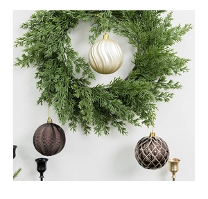 Detailed view of 8cm textured Christmas balls hanging on a green pine needle wreath
