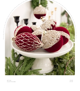 Vue détaillée des boules de Noël en velours rouge foncé avec perles dorées