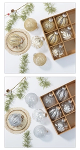 Detail view of gold and silver Christmas ornaments with glitter patterns and kraft gift box