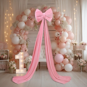 Large pink velvet decorative bow with long tassels for birthday party scene setup