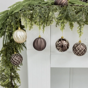 Set of 16 elegant 8cm Christmas balls with relief patterns on a festive mantelpiece